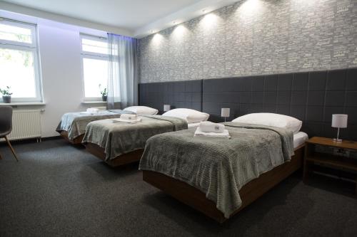 um quarto com 3 camas e uma parede de tijolos em N°50 em Poznań