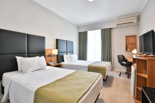 Ένα ή περισσότερα κρεβάτια σε δωμάτιο στο Comfort Ibirapuera