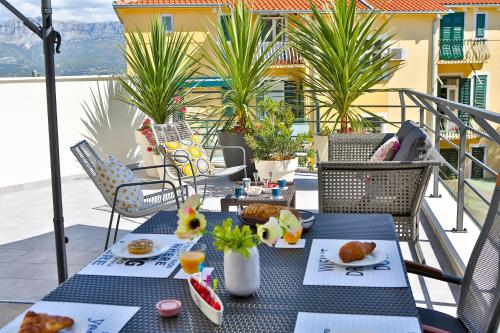 a table with plates of food on a balcony at Luxury Urban Villa Apartments With Jacuzzi in Split