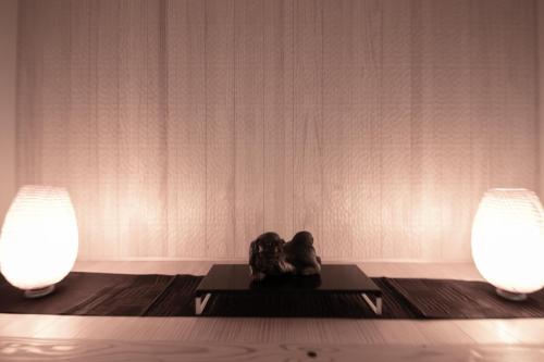 two people sitting on a table between two lights at Oyado Den Rikyu in Yufuin