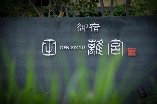 a sign with chinese writing on a wall at Oyado Den Rikyu in Yufuin