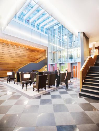a lobby with a checkered floor and stairs at Mövenpick Hotel Stuttgart Airport in Stuttgart