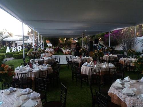 a group of tables and chairs with white dishes on them at Hotel No Que No in Tepexi del Río