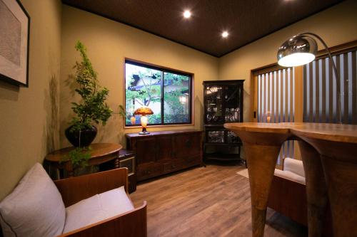 a living room with a table and a window at Oyado Den Rikyu in Yufuin