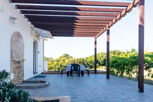 an outdoor patio with a wooden pergola at Naiada Stomio-A apartment in Filiatra