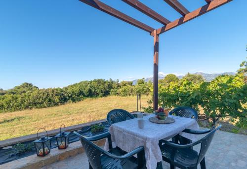a table and chairs on a patio with a view at Naiada Stomio-A apartment in Filiatra