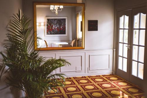 a hallway with a mirror and a potted plant at Illyrian Boutique Hotel in Sarandë