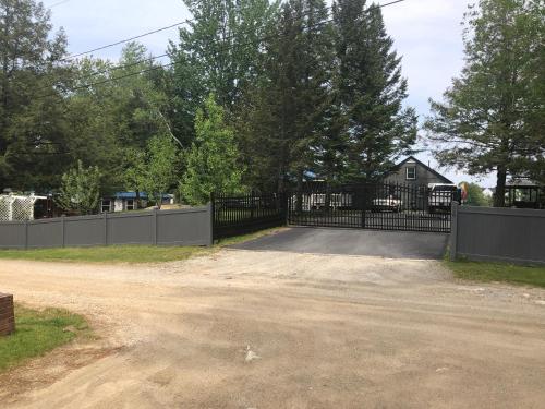 a driveway with a black gate and a house at Welcome to the Lake in Northwood