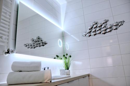 a white bathroom with a sink and a mirror at Onyx Aquamarina by Baltico Apartament in Międzyzdroje