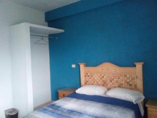 a blue bedroom with a bed and a blue wall at Altabrisa Departamento 2 habitaciones in Villahermosa