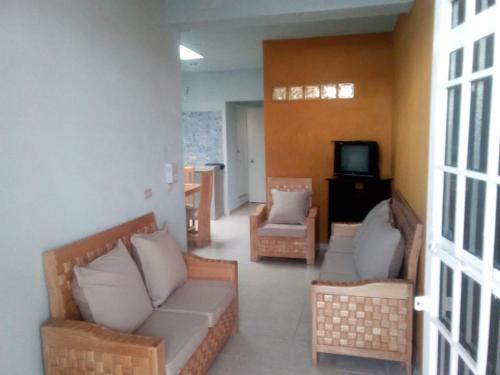 a living room with two couches and a television at Altabrisa - Deportiva Departamento cómodo y silencioso 2 habitaciones in Villahermosa