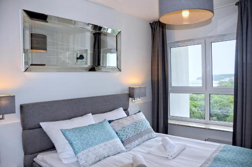 a bedroom with a bed and a large window at Onyx Aquamarina by Baltico Apartament in Międzyzdroje