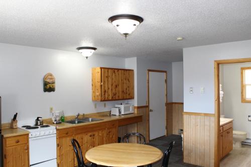 uma cozinha com uma mesa, um lavatório e um fogão em Alpine Motel of Cooke City em Cooke City