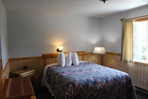 a bedroom with a bed with two pillows on it at Alpine Motel of Cooke City in Cooke City