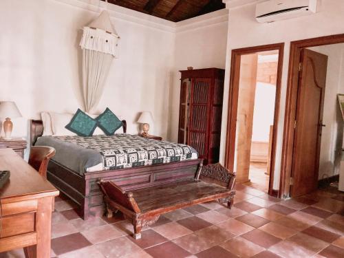 a bedroom with a bed and a bench in it at Bale Asri Bukit Jimbaran in Jimbaran