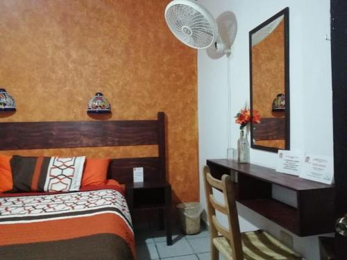 a bedroom with a bed and a desk and a mirror at Kali Huasteca Posada in Ciudad Valles