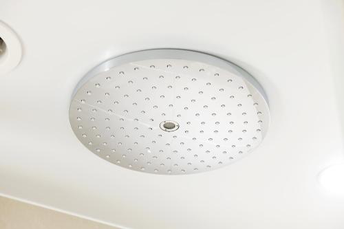 a shower head in a bathroom with a white ceiling at remm plus Ginza in Tokyo