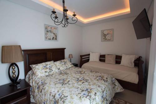 a bedroom with a bed and a table with a lamp at Quinta das Perdizes - Premium in Ponta Delgada