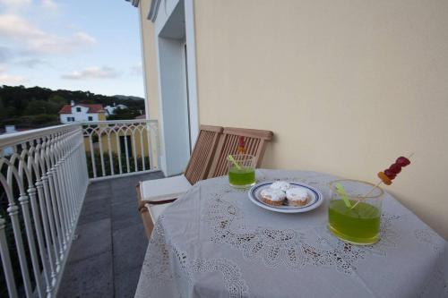 a table with a plate of food on a balcony at Quinta das Perdizes - Premium in Ponta Delgada