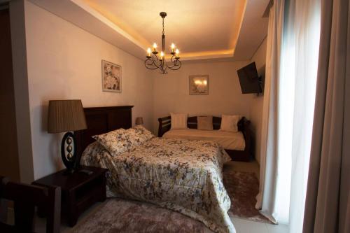 a bedroom with two beds and a chandelier at Quinta das Perdizes - Premium in Ponta Delgada