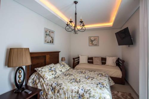 a bedroom with a bed and a chandelier at Quinta das Perdizes - Premium in Ponta Delgada