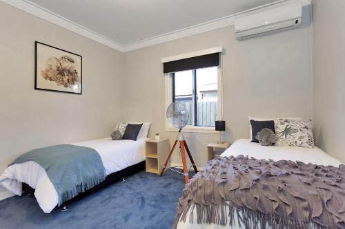a bedroom with two beds and a window at North Central Holiday Home in North Mackay