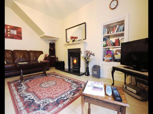 a living room with a couch and a fireplace at Sive Budget Accommodation in Cahersiveen
