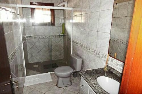a bathroom with a toilet and a sink and a shower at Casarão Villa maggi in Canela