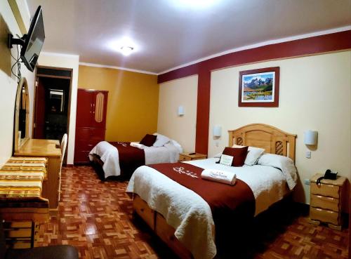 a hotel room with two beds and a television at Morales Guest House in Huaraz