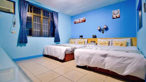 溫泉村的住宿－月娘坡，蓝色的客房设有两张床和窗户。
