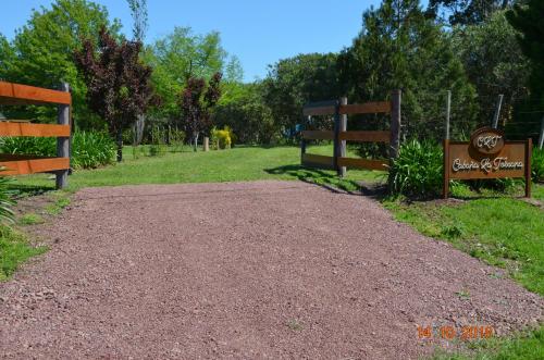 a dirt road with two signs in a park at CABAÑA LA TOSCANA in Carmelo