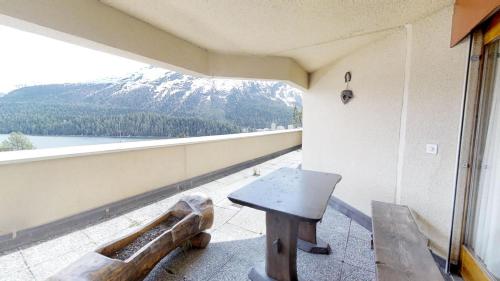 a balcony with a table and a view of a mountain at Caspar Badrutt - St. Moritz in St. Moritz