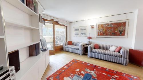a living room with two couches and a tv at Caspar Badrutt - St. Moritz in St. Moritz