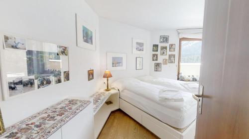 two beds in a white room with a window at Caspar Badrutt - St. Moritz in St. Moritz