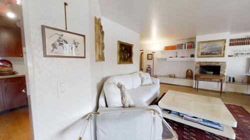 a living room with a white couch and a table at Caspar Badrutt - St. Moritz in St. Moritz
