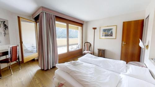 a bedroom with a large white bed and a window at Caspar Badrutt - St. Moritz in St. Moritz