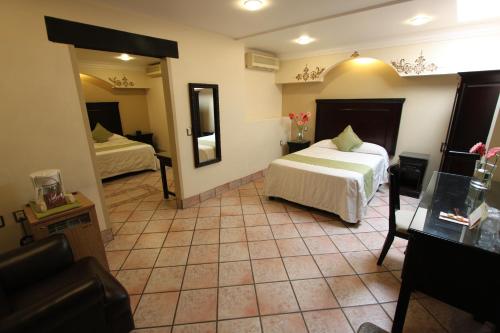 a hotel room with two beds and a mirror at Hotel CasAntica in Oaxaca City