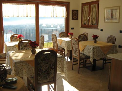 uma sala de jantar com mesas e cadeiras e uma janela em Agritur Vista Lago em Revò