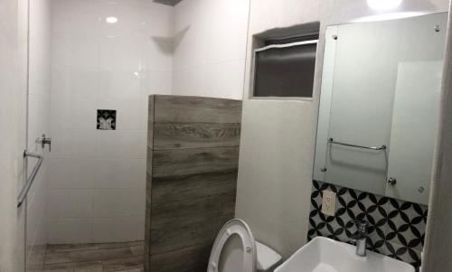 a small bathroom with a toilet and a shower at Hotel Gallo in Guadalajara