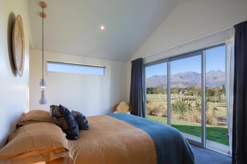 a bedroom with a bed and a large window at The Arrow Nest in Arrowtown