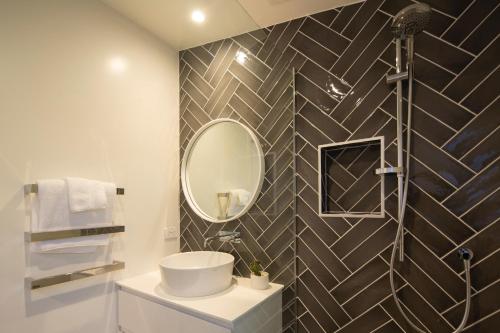 een badkamer met een wastafel en een spiegel bij The Arrow Nest in Arrowtown