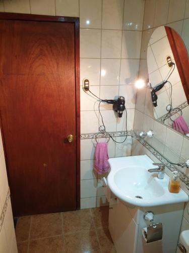 a bathroom with a sink and a mirror at La Casa Guesthouse in Punta Arenas