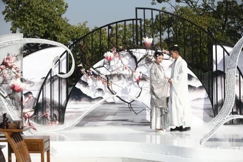 two men standing in front of a gate with flowers at Zhejiang Xizi Hotel in Hangzhou