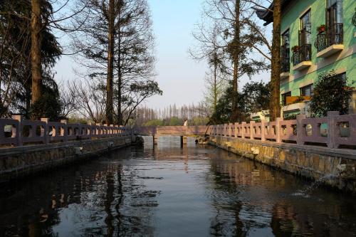 a bridge over a river next to a building at Zhejiang Xizi Hotel in Hangzhou