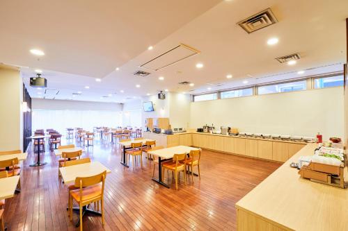 an empty classroom with tables and chairs in a cafeteria at Hotel Wing International Kobe - Shinnagata Ekimae in Kobe