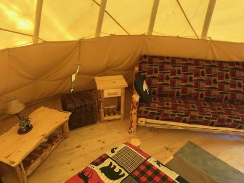 a room with a tent with a table and a rug at Eycat Lodging Company in Wapiti
