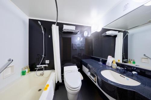 a bathroom with a toilet and a sink at Hotel Wing International Kobe - Shinnagata Ekimae in Kobe