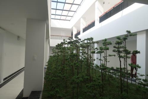 a room with trees in the middle of a building at Garco Dragon Hotel 2 in Hanoi