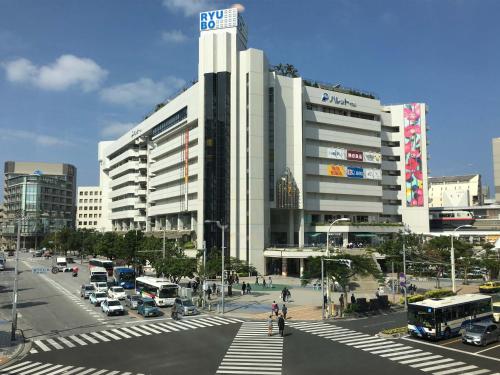 a large white building with a sign on top of it at CABIN&HOTEL ReTIME in Naha