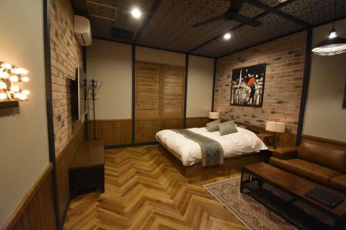 Hotel Pinon - Adult Only في Kai: غرفة نوم بسرير واريكة